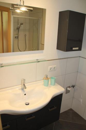ein Bad mit einem Waschbecken und einem Spiegel in der Unterkunft Haus Eder in Maurach