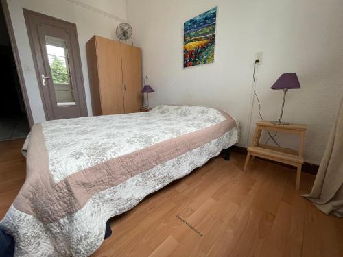 een slaapkamer met een bed en een tafel met een lamp bij La Résidence - n° 08 - T2 classé** in Gréoux-les-Bains