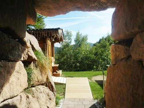 a stone wall with a pathway leading to a house at Apartment Hotel Christine in Avelengo
