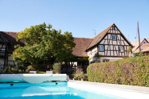 una piscina frente a una casa en La Cour de Lise Maison D'Hôtes et SPA en Willgottheim