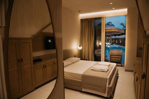 a bedroom with a bed and a view of a resort at Elite Bay Hotel Lalez Durres in Lalëz