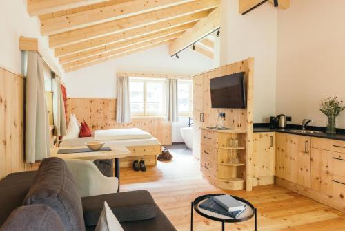 ein Wohnzimmer mit einem Sofa und einem TV in der Unterkunft feelfree - Natur & Aktiv Resort Ötztal in Oetz
