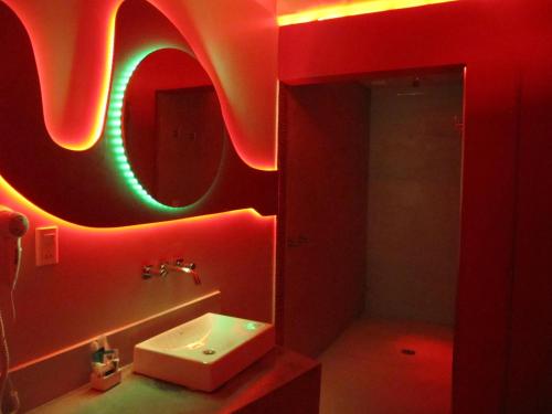a red bathroom with a sink and a mirror at Uman Hotel -Motel- in Buenos Aires