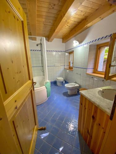 bagno con 2 servizi igienici, lavandino e vasca di Casa Stelin a Casso