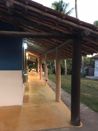 a covered walkway in a park with palm trees at Céu Azul Pousada in Arraial d'Ajuda
