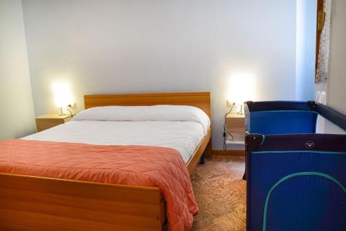een slaapkamer met een bed en een blauwe koffer bij Hidden Terrace With Lake View in Dongo