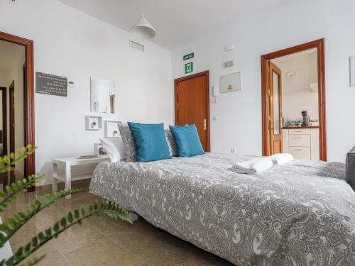 a bedroom with a large bed with blue pillows at Alcalá del Rio! 1A in Alcalá del Río