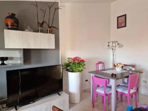 uma sala de estar com uma mesa e cadeiras cor-de-rosa em Appartamento Capo Mannu-mandriola em Putzu Idu