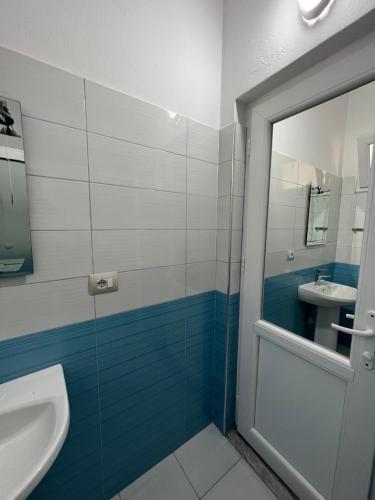 a bathroom with a sink and a toilet and a mirror at Bianca Apartments in Velipojë