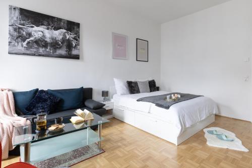 biała sypialnia z łóżkiem i stolikiem kawowym w obiekcie Yeshello Vienna Central Station Apartment w Wiedniu