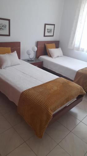 two beds sitting next to each other in a room at Apartamento Solar dos Pinheiros in Vilamoura