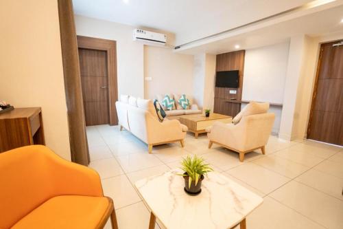 a living room with a couch and chairs and a table at Samasth Palatial in Mysore