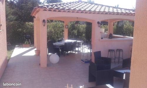 une terrasse avec une table et des chaises dans une maison dans l'établissement La maison du bonheur, à Gréoux-les-Bains