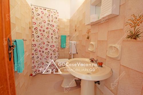 トッレ・パリにあるGDCaseVacanza - Sulla Spiaggia Maldive del Salento -のバスルーム(洗面台、トイレ、尿路付)