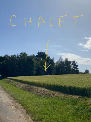 a kite flying in the sky over a field at Maison 2 chambres proche Dijon chalet niché dans la nature in Saint-Maurice-sur-Vingeanne