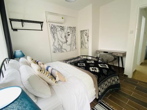 a bedroom with a white bed with drawings on the wall at Engomi Apartment in Yukarı Lakatamya