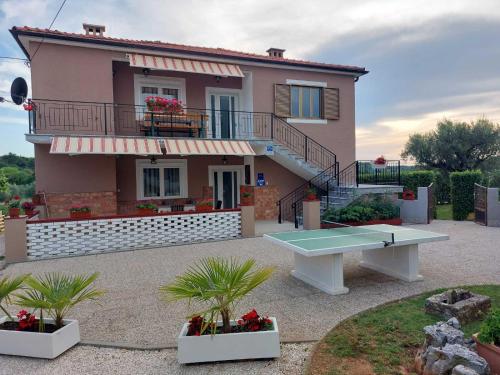 a house with a table tennis court in front of it at Apartments Bakša in Kanfanar