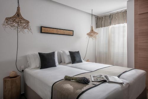2 łóżka w pokoju z białymi ścianami w obiekcie Khroma Luxury Suite 2 Beach front apartment w mieście Hersonissos