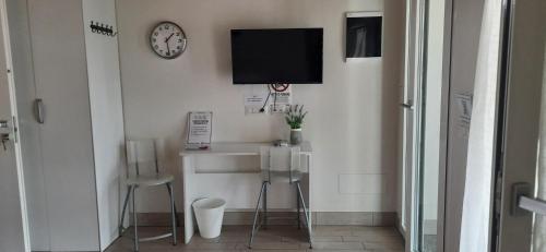 a bathroom with a sink and a clock on the wall at La Casa Di Emma in Rozzano