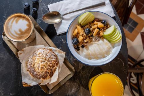 a table with a bowl of cereal and a bowl of fruit at Assemblage Boutique in Tel Aviv