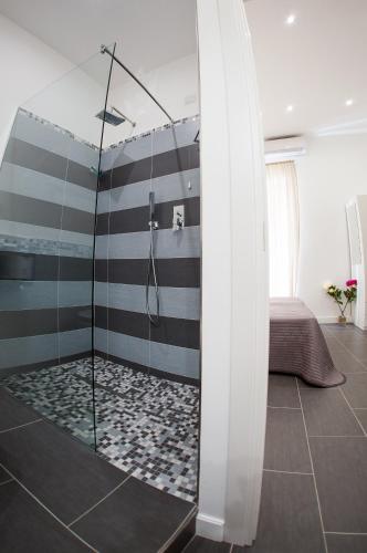 a shower with a glass door in a bathroom at B&B Diana in Piazza Armerina