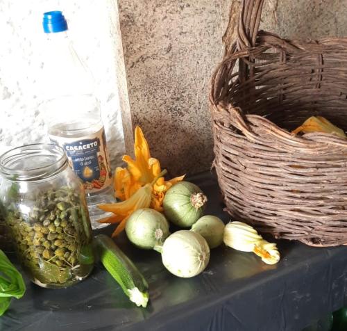 une table avec des légumes et un panier dans l'établissement Trullo Antelmi, à Ceglie Messapica