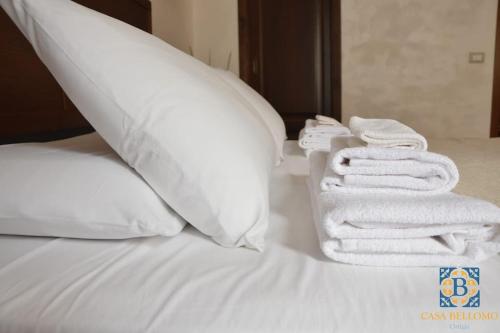 een stapel handdoeken bovenop een bed bij Casa Bellomo Ortigia in Siracusa