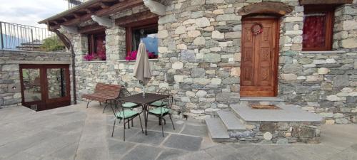 un patio con mesa y sillas y un edificio en A due passi da..., en Aosta