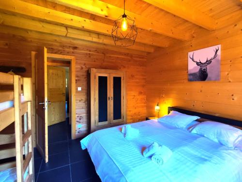sypialnia z łóżkiem w drewnianym domku w obiekcie ⁂⁂ LE NID DE PIERRE & JULIE [CLEDICIHOME] 2 pas du centre ville / SPA & TERASSE AMENAGEE ⁂⁂ w mieście La Bresse