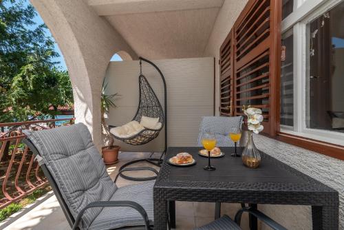 una mesa y sillas en un porche con copas de vino en Apartments Villa Mirella 20 m from the sea - free parking en Trogir