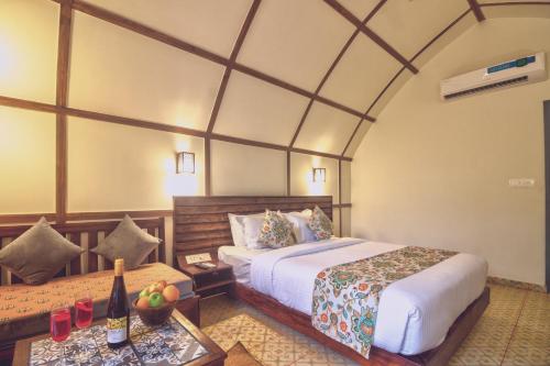 a bedroom with a bed and a table with a bottle of wine at Pause By The Sea in Morjim