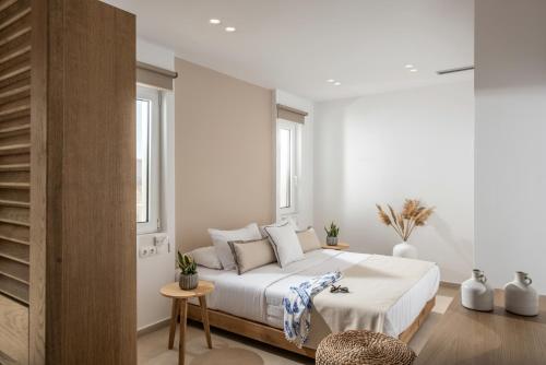 um quarto com uma grande cama branca num quarto em Aether by Nymphs residence II em Kókkinos Pírgos