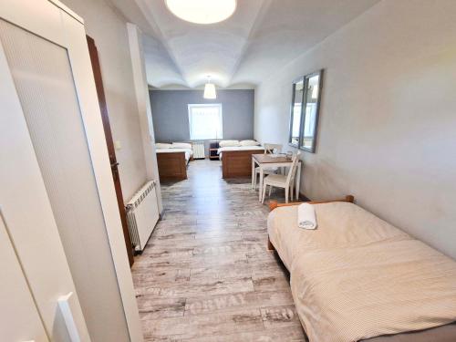 a small room with a bed and a table at Zielona Przystań in Manasterz