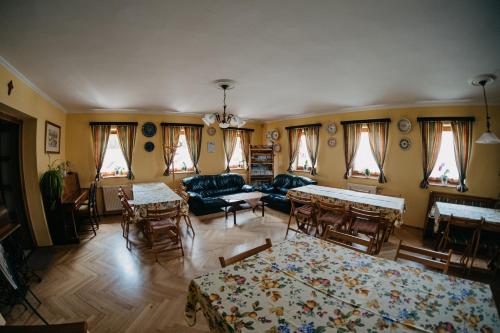 sala de estar con mesas y sofá en Hemina Vendégház, en Tata