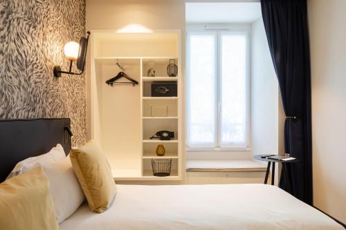 a bedroom with a bed and a window at Hôtel Prince Albert Gare de Lyon in Paris