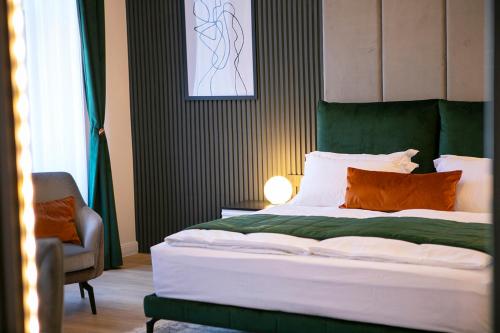 a bedroom with a bed with a green headboard and a chair at House Of Charles in Carei
