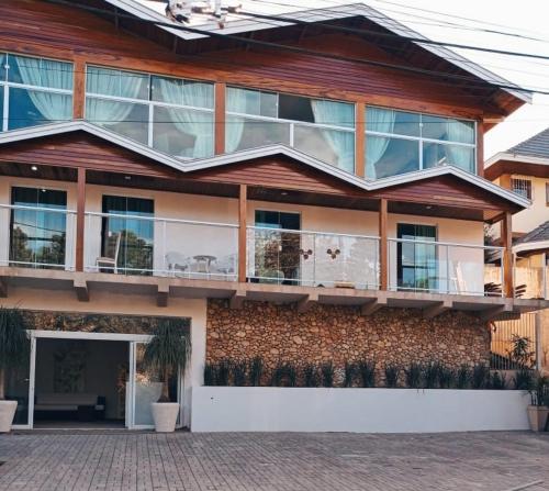 a house with a balcony on the side of it at Pousada Serrano in Campos do Jordão