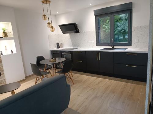 a kitchen with black cabinets and a table and chairs at Préstige in Rouilly-Sacey