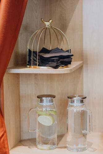 a shelf with a bird cage and two glass vases at Hôtel Prince Albert Gare de Lyon in Paris