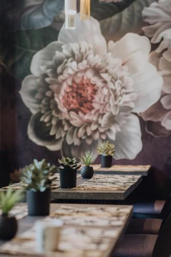 a table with potted plants and a wall with flowers at Hôtel Prince Albert Gare de Lyon in Paris