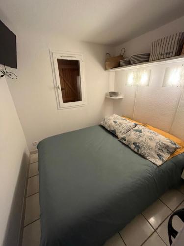 une chambre avec un lit avec un oreiller dessus dans l'établissement Aux Ayguades, Pavillon tout confort proche plage, terrasse et WIFI, à Gruissan