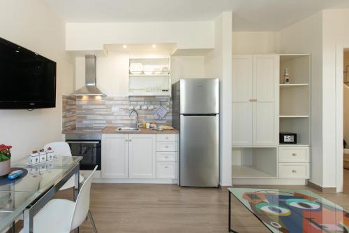 a kitchen with a stainless steel refrigerator and a table at MNP Apartments in Engares
