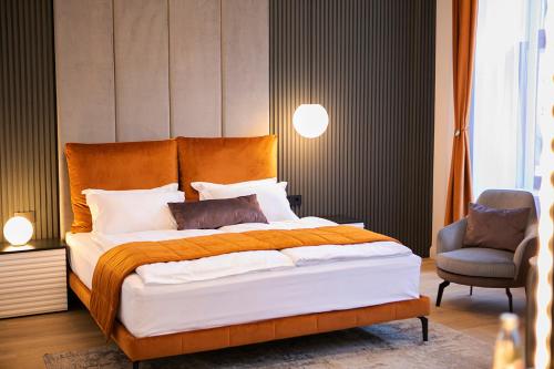 a bedroom with a large bed and a chair at House Of Charles in Carei