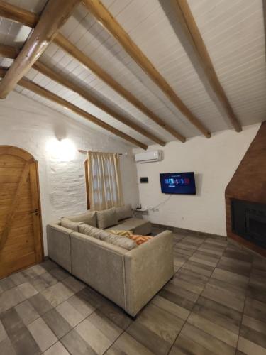 a living room with a couch and a tv at Casa Huellas de Malbec - Montaña y paz in Las Compuertas