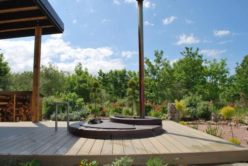 una terraza de madera con un pabellón en un jardín en Peaceful Bothy Retreat en Nairn