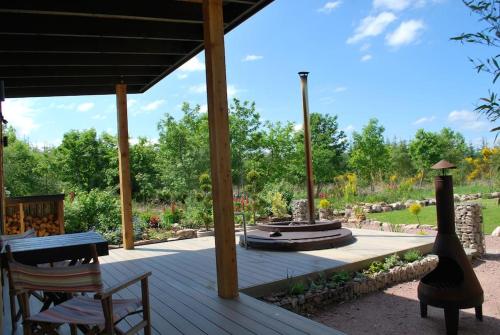 a wooden deck with a fountain in a garden at Peaceful Bothy Retreat in Nairn
