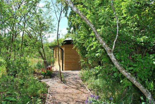 a small wooden shed in the middle of a garden at Peaceful Bothy Retreat in Nairn