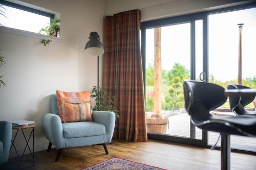 a living room with a chair and a window at Peaceful Bothy Retreat in Nairn