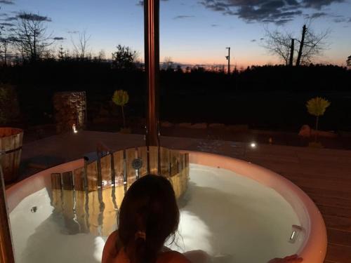 a woman in a jacuzzi tub with the sunset at Peaceful Bothy Retreat in Nairn