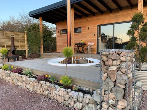 a wooden deck with a fountain in front of a house at Peaceful Bothy Retreat in Nairn
